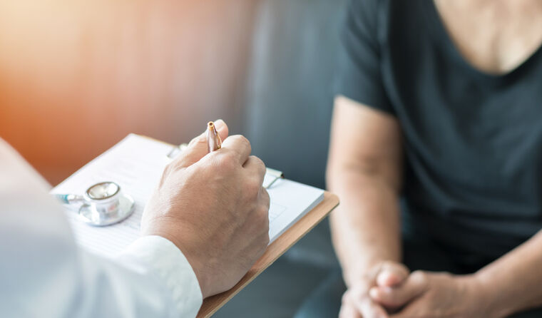 Geriatric doctor (geriatrician) consulting and diagnostic examining elderly senior adult patient (older person) on aging and mental health care in medical clinic office or hospital examination room